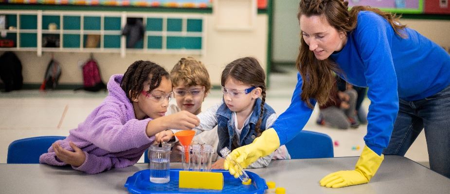 Child watch a science experiment led by a teacher