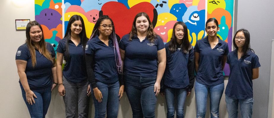 Teen Action Committee standing in front of a mural