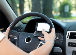 A photo of someone trying to text while driving. 