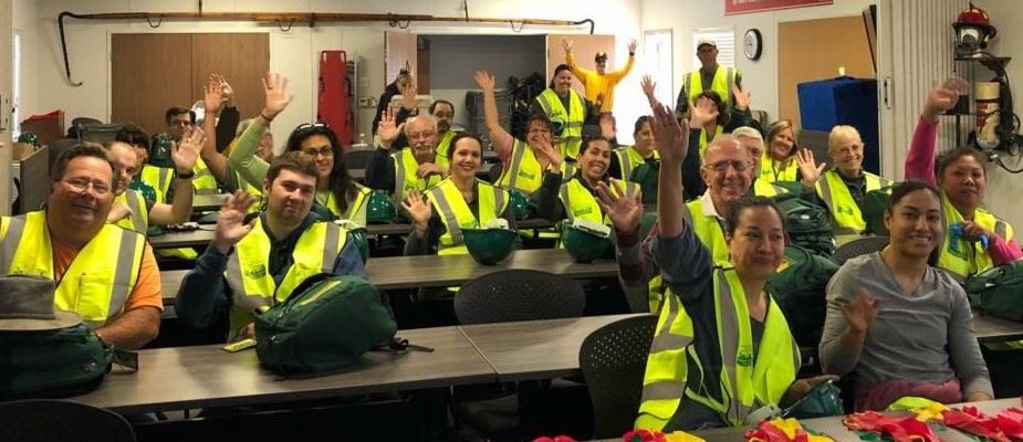 People raising hands in classroom during CERT training