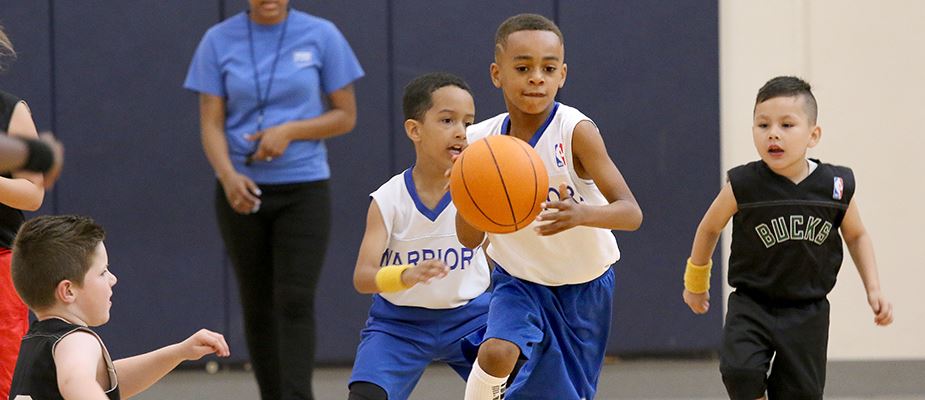 Boy dribbling a basketball up the court during a game