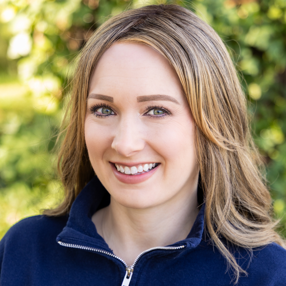 A blonde teacher smiles at the camera.