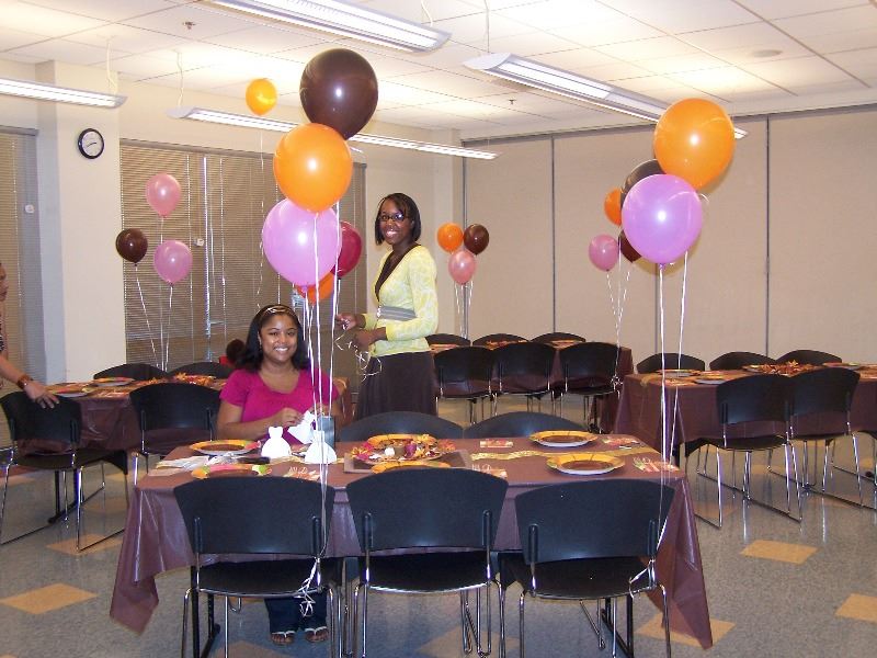 Two renters smile as they decorate a room for a party