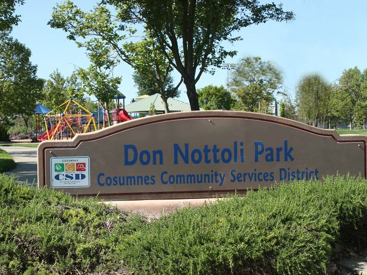Park sign with blue sky and surrounded by pretty landscaping