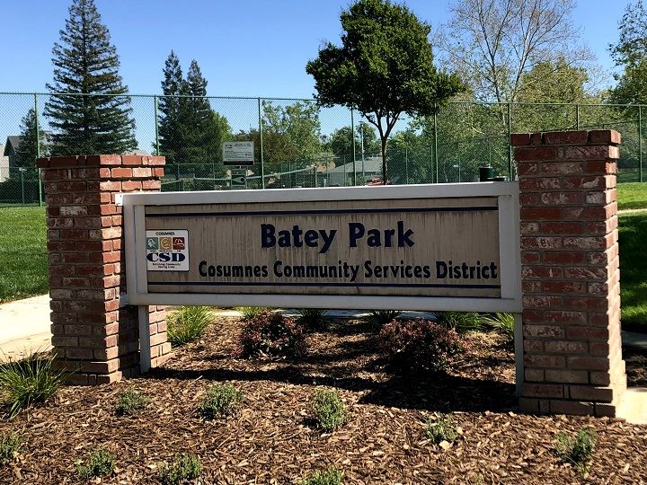 Park sign with tennis courts in the background