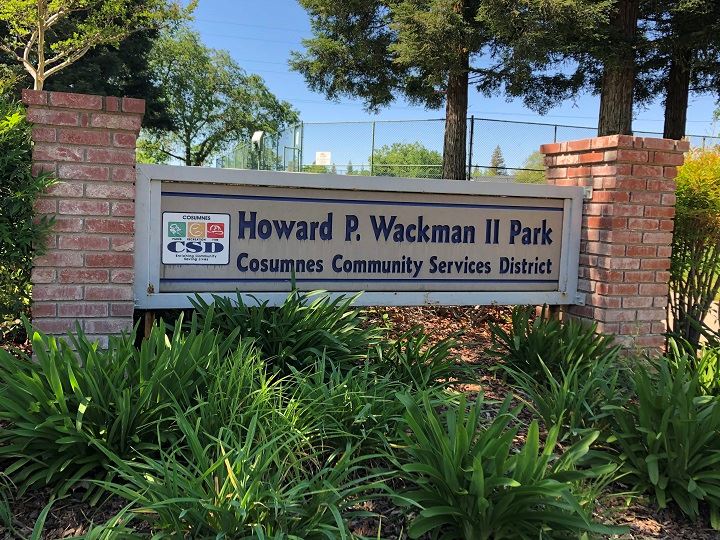 Park sign with brick pillars and green shrubs